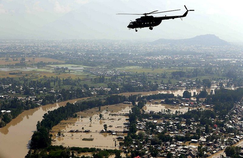In this photograph released by the Indian Air Force, a chopper flies over flood-affected Srinagar in Indian-controlled Kashmir, Saturday, Sept. 13, 2014. Flash floods have killed hundreds, washed away crops, damaged tens of thousands of homes and affected over a million people since Sept. 3, when heavy monsoon rains lashed Pakistan's eastern Punjab province and the Kashmir region, claimed by both India and Pakistan.  (AP Photo/Indian Air Force)
