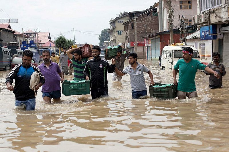 Kashmiri volunteers carry relief material towards flood-affected localities in Srinagar, Indian-controlled Kashmir, Friday, Sept. 12, 2014. Officials said the flooding has killed 200 people in India, where anger and resentment was mounting over what victims described as a slow rescue and relief effort. (AP Photo/Dar Yasin)