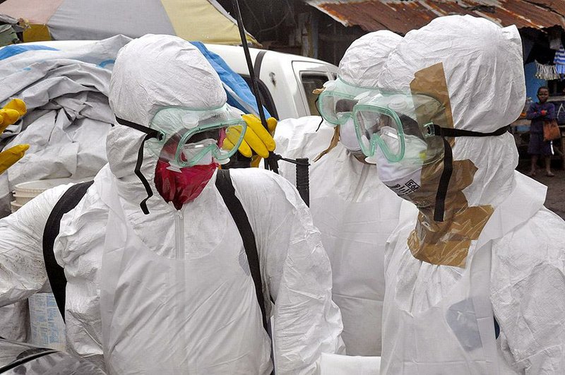 Health workers finish up last week after removing the body of a woman they suspect died of Ebola in the Clara Town area of Monrovia, Liberia.