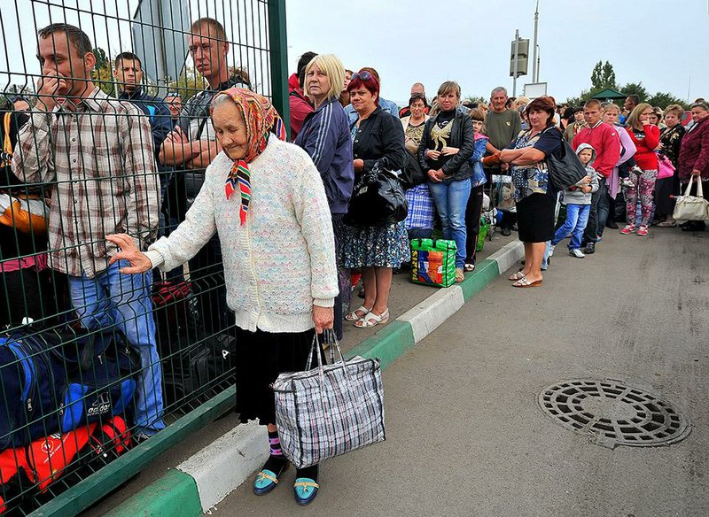 Ukrainian refugees line up to return to their homes in eastern Ukraine at the Russia-Ukraine border check point in the Russian town Donetsk, Rostov-on-Don region, Russia, Friday, Sept. 12, 2014. The ceasefire in eastern Ukraine has largely held. (AP Photo)