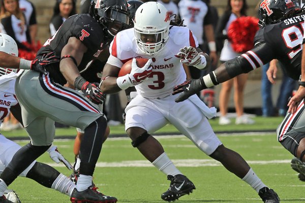 Arkansas running back Alex Collins (3) finds an opening between two Texas Tech defenders in the 3rd q of their game at Jones AT&T Stadium in Lubbock Saturday on Sept. 13, 2014.