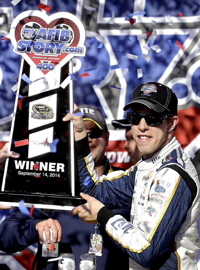 Brad Keselowski holds up the trophy in Victory Lane after winning the NASCAR Sprint Cup series auto race at Chicagoland Speedway in Joliet, Ill., Sunday, Sept. 14, 2014. (AP Photo/Nam Y. Huh)