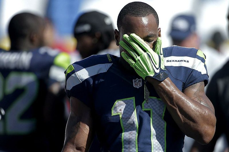 Seattle Seahawks wide receiver Percy Harvin wipes his face in the final minutes of the game while playing the San Diego Chargers during the second half of an NFL football game on Sunday, Sept. 14, 2014, in San Diego. The Chargers won, 30-21. (AP Photo/Gregory Bull)