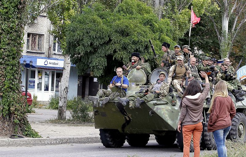 Residents wave to Pro-Russian rebels atop an armored personal carrier during a parade in the town of Luhansk, eastern Ukraine, Sunday, Sept. 14, 2014. Some semblance of normality is returning to parts of eastern Ukraine after a cease-fire agreement sealed between Ukrainian government forces and separatist rebels earlier this month, although exchanges of rocket fire remain a constant in some areas. (AP Photo/Darko Vojinovic)