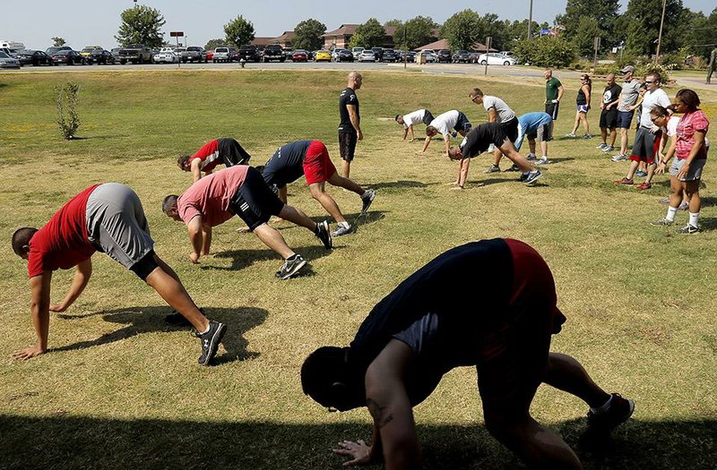 Arkansas Democrat-Gazette/JOHN SYKES JR. - A program at Little Rock Air Force Base called Vital 90 combines elements of several fitness routines to keep the base personnel in shape. Program participants do a warmup exercise 