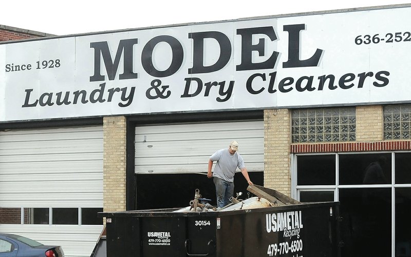 STAFF PHOTO FLIP PUTTHOFF Dalton Blackman stands Thursdsay among scap metal hauled from the interior of the former Model Laundry in downtown Rogers.