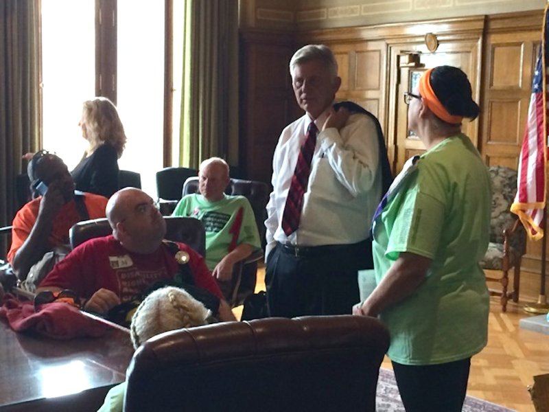 Gov. Mike Beebe addresses members of ADAPT, a disability rights group, in his conference room Monday morning. The group marched to the Capitol for the support of the Community First Choice Option. 