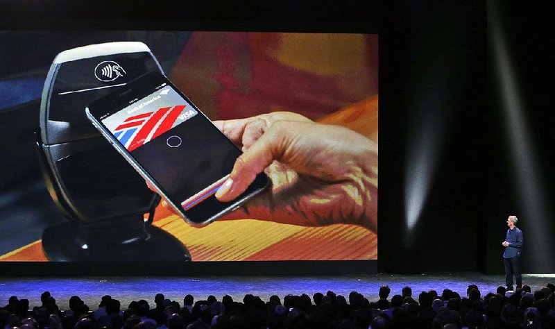 FILE - In this Tuesday, Sept. 9, 2014, file photo, Apple CEO Tim Cook introduces the new Apple Pay product in Cupertino, Calif. Some experts believe Apple Pay, with its presence on millions of iPhones and its advanced security features, could be the service that leads to widespread adoption of the so-called mobile wallet. (AP Photo/Marcio Jose Sanchez, File)