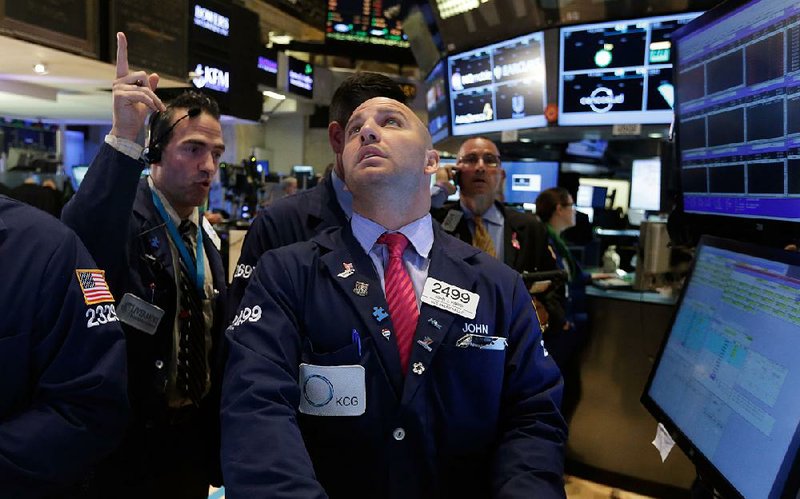 Specialist John Parisi, center, works at his post on the floor of the New York Stock Exchange, Monday, Sept. 15, 2014. The stock market is down slightly in early trading after its first weekly loss since early August.  (AP Photo/Richard Drew)