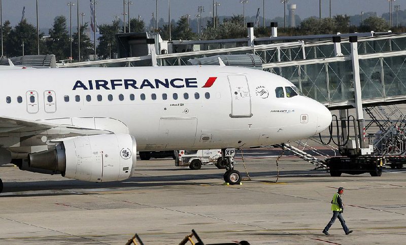 An Air France plane is parked on the tarmac at Paris Charles de Gaulle Airport in Roissy, near Paris, Monday, Sept. 15, 2014. At least half of Air France flights around the world were canceled Monday as pilots kicked off a weeklong strike, angry that the airline is shifting jobs and operations to a low-cost carrier to better keep up with competition.  (AP Photo/Christophe Ena)