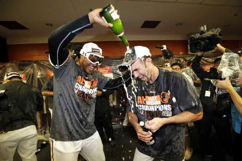 Baltimore’s Jonathan Schoop (left) and J.J. Hardy celebrate after the Orioles beat Toronto 8-2 on Tuesday to win their first American League East division title since 1997.