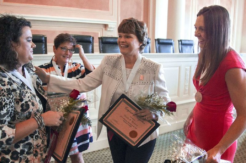 The four Arkansas Teacher of the Year finalists (from left) Lindsay Griffin of Greenbrier Middle School, Donna Dillahunty of Marion Intermediate School, Ouida Newton of Poyen High School, and Jayna Moffit of Lincoln Junior High School in Bentonville, celebrate after being selected from a group of teachers from around the state during a ceremony Tuesday at the state Capitol.