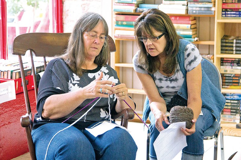 Joyce Williams, left, shows Judy Purnell how to accomplish a complicated stitch during a knitting lesson taught by Williams.