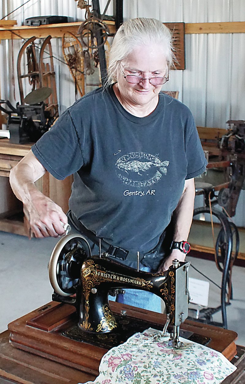 Photo by Randy Moll Ann Burger demonstrates a hand-crank Frister and Rossmann sewing machine on Friday at the Tired Iron of the Ozarks show grounds in Gentry.