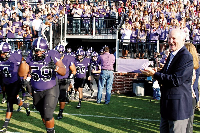 Cliff Harris applauds the Ouachita Tigers as the team from his alma mater takes the field for the first game in the new stadium named for Harris, who played for the Tigers in Arkadelphia, then went on to have an All-Pro career with the Dallas Cowboys in the NFL