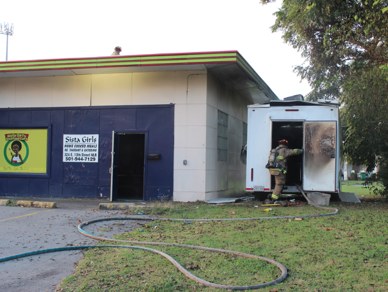 A North Little Rock firefighter steps inside a burned catering trailer after the flames were extinguished.