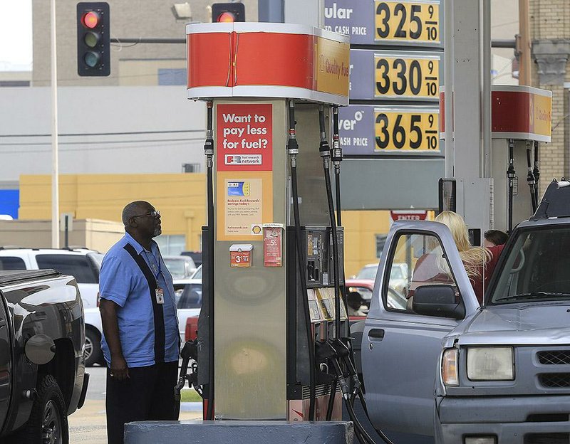 Motorists fill up their gas tanks Wednesday morning at the Shell station at Eighth Street and Broadway in downtown Little Rock.