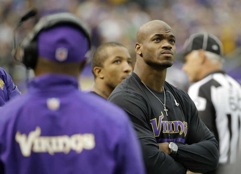  In this Dec. 29, 2013, file photo, Minnesota Vikings running back Adrian Peterson stands on the sidelines during the first half of an NFL football game against the Detroit Lions in Minneapolis.  After a day of public pressure from angry fans and concerned sponsors, the Vikings have reversed course and placed star  Peterson on the exempt-commissioner's permission list, the team announced Wednesday, Sept. 17, 2014. The move that will require him to stay away from the team while he addresses child abuse charges in Texas. 