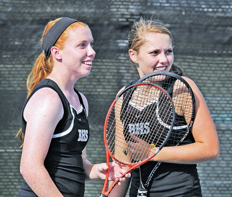  STAFF PHOTO BEN GOFF &#8226; @NWABenGoff Mallory Tabler, left, and doubles partner Kendra Dinsmore of Bentonville share a laugh between points while competing in the No.1 match against Springdale at the Memorial Park tennis courts in Bentonville on Monday.