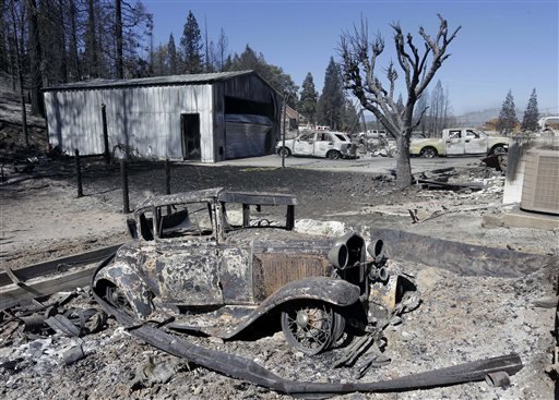 An antique car sits among the ruins of a burned out garage that was destroyed by a fire in Weed, Calif., Tuesday, Sept. 16, 2014. In just a few hours Monday, wind-driven flames destroyed or damaged roughly 100 homes.