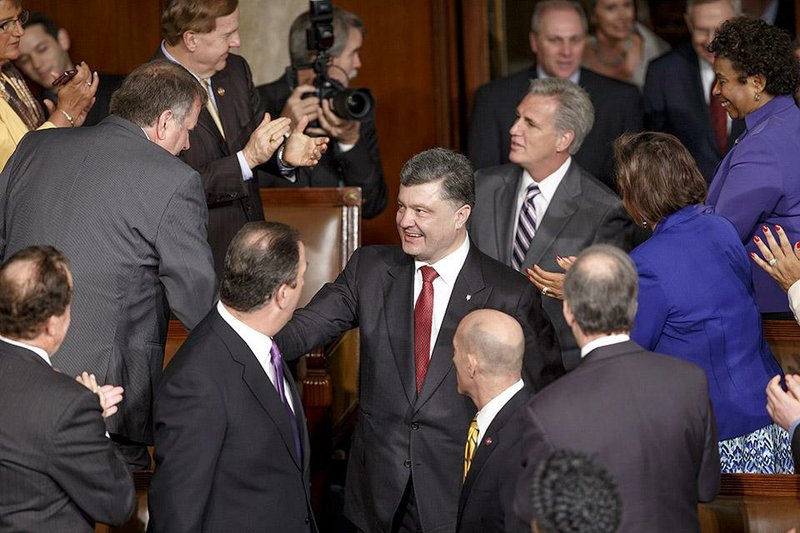 Ukrainian President Petro Poroshenko, escorted by House Majority Leader Kevin McCarthy, R-Calif., center right, is welcomed by U.S. lawmakers as he arrives to address a joint meeting of Congress, at the Capitol in Washington, Thursday, Sept. 18, 2014. Poroshenko is seeking more robust U.S military assistance to help his country in its fight against Russian-backed rebels and will also be meeting with President Barack Obama.  (AP Photo/J. Scott Applewhite)