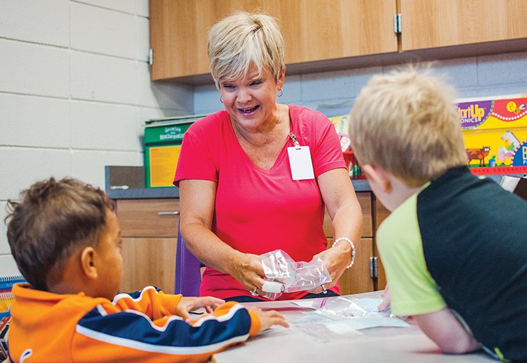 Mar’Trell Jergins, left, and Logan Price listen as Suzanne Harrell works with them on their reading skills during the Mentors and Mimis program at Mayflower Elementary School. Principal Candie Watts said members of Oasis Church in North Little Rock helped residents during the April tornado and wanted to continue to volunteer in the community.