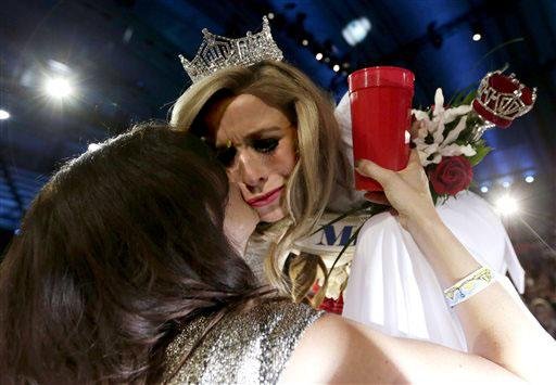 Newly crowned Miss America Kira Kazantsev (right) gets a kiss from her mother, Julia Kazantsev, victory cup in hand.