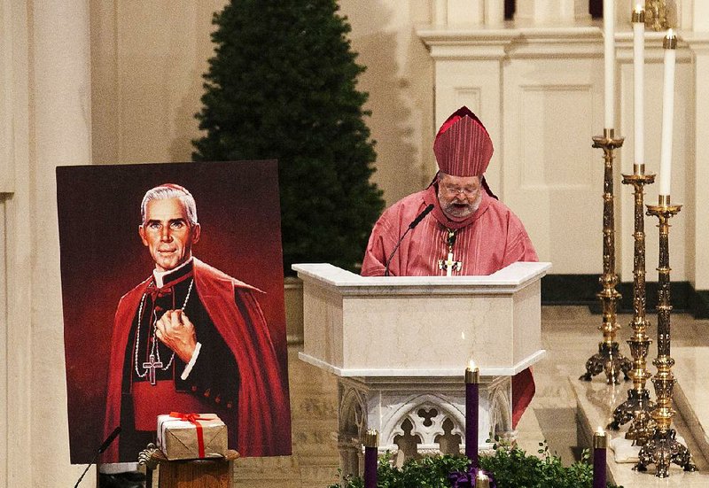 Bishop Daniel Jenky, seen in this 2011 photo, gives a sermon next to a painting of Archbishop Fulton J. Sheen and a box containing documentation for the miracle allegedly performed by the late archbishop.