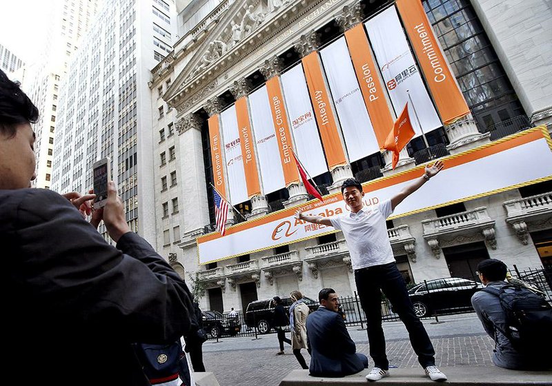 Jiang Nan of Beijing poses outside the New York Stock Exchange on Friday, the first day for public trading of shares of Chinese ecommerce company Alibaba.