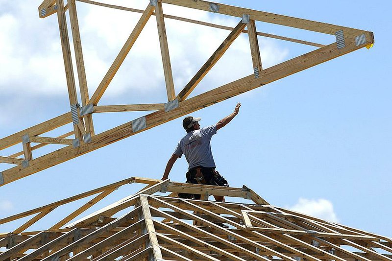 A construction worker installs a truss for the roof of a commercial complex in Springfield, Ill., in July. A gauge that predicts the economy’s future health rose in August but at a much slower pace than in July.