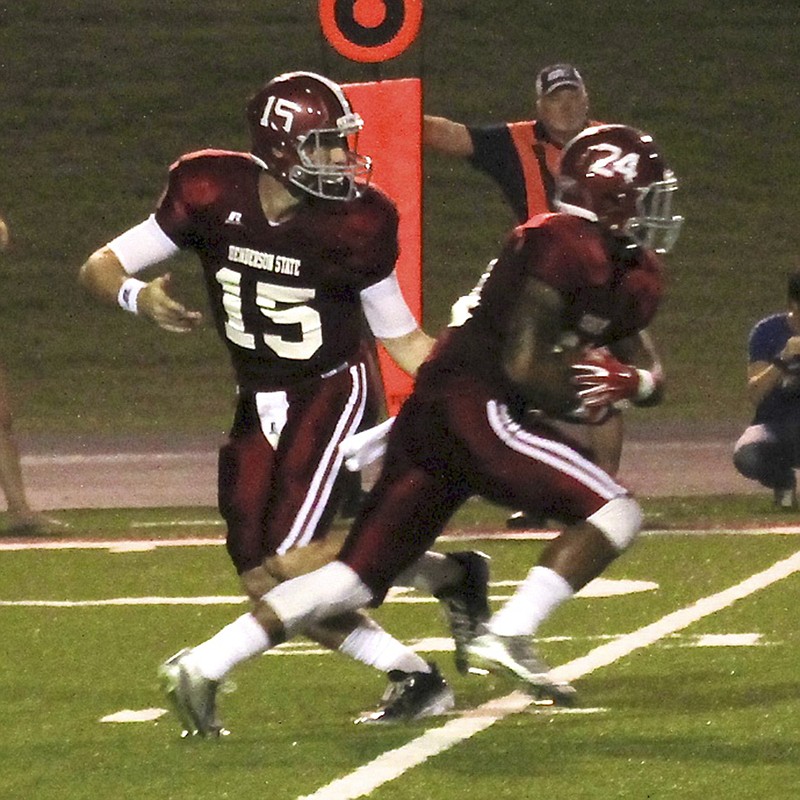 The Sentinel-Record/Verlin Price RECORD SETTER: Henderson State quarterback Kevin Rodgers (15) sets an Arkansas collegiate record for career passing yardage and throws his 100th career touchdown pass Thursday night as the Reddies clobber Southeastern Oklahoma 60-17 at Carpenter-Haygood Stadium in Arkadelphia.
