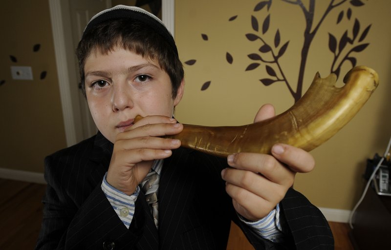 FILE PHOTO Julian Sherr blows his great-grandfather&#8217;s shofar, a ram&#8217;s horn, in 2011 at his Rogers home. Blowing the shofar is an important part of the Jewish observance of Rosh Hashanah. It serves as a &#8220;wakeup call&#8221; for Jews to repair their relationships on earth and with God, explained Rabbi Rob Linnick, currently serving congregation Etz Chaim in Bentonville.