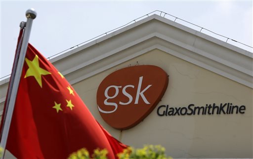 In this July 24, 2013 file photo, a Chinese flag is hoisted in front of a GlaxoSmithKline building in Shanghai, China. Drug maker GlaxoSmithKline was fined $492 million on Friday, Sept. 19, 2014 for bribing doctors in China in the biggest such penalty ever imposed by a Chinese court. The court sentenced the company's former China manager, Briton Mark Reilly, and four Chinese co-defendants to prison but postponed the sentences for two to four years, suggesting they may never be served. The court said it granted leniency because the defendants confessed. 