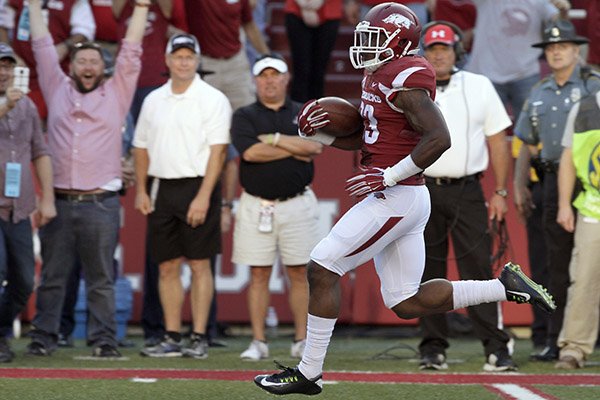Arkansas running back Korliss Marshall runs for a touchdown after catching the kickoff in the first quarter of an NCAA college football game against Northern Illinois in Fayetteville, Ark., Saturday, Sept. 20, 2014. (AP Photo/Danny Johnston)