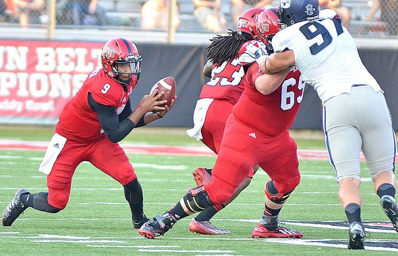 Arkansas State quarterback Fredi Knighten follows the blocks of J.D. McKissic (23) and Alan Wright (69) in the first quarter of a 21-14 overtime victory Saturday in Jonesboro.