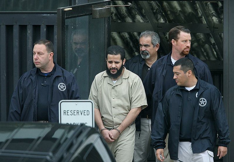In this Thursday, Sept. 18, 2014 photo, Mufid Elfgeeh is taken out of Federal Court in Rochester, N.Y.   Elfgeeh is accused of plotting to kill members of the U.S. military and others pleaded not guilty Thursday to new federal charges that he tried to aid the Islamic State group in Syria and Iraq.  With foreign fighters from dozens of nations pouring into the Middle East to join the Islamic State group and other terrorist organizations, U.S. officials are putting new energy into trying to understand what radicalizes people far removed from the fight and into prodding countries around the world to do a better job of keeping them from joining up.   (AP Photo/Democrat & Chronicle, Carlos Ortiz)  MAGS OUT; NO SALES