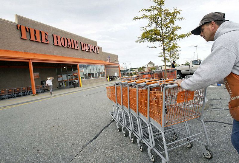 FILE - In this file photo made Oct. 6, 2009, employee John Abou Nasr pushes shopping carts in the parking lot of a Home Depot in Methuen, Mass. Home Depot’s data breach could wind up being among the largest ever for a retailer, but that may not matter to its millions of customers. (AP Photo/Elise Amendola, File)