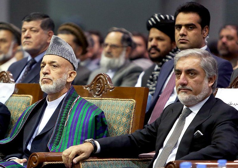 Afghan President Hamid Karzai, left, and Afghan presidential candidate Abdullah Abdullah attend a ceremony to mark the third anniversary of the assassination of former Afghan President Burhanuddin Rabbani in Kabul, Afghanistan, Saturday, Sept. 20, 2014. In 2011, an insurgent with a bomb wrapped in his turban assassinated Rabbani, who was leading a government effort to broker peace with the Taliban. (AP Photo/Rahmat Gul)