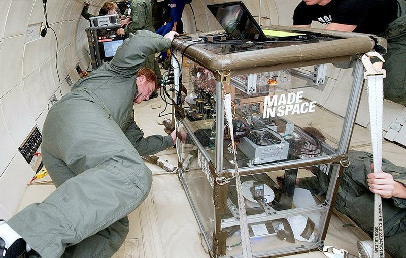 In this undated photo provided by Made In Space, Michael Snyder and Aaron Kemmer monitor the performance of extruders inside the Made In Space experiment box during a microgravity portion of flight aboard a modified Boeing 727 from the Zero G Corporation. NASA is sending a 3-D printer to the International Space Station in hopes that astronauts will be able to one day fix their spacecraft  by cranking out spare parts on the spot. (AP Photo/Made In Space)