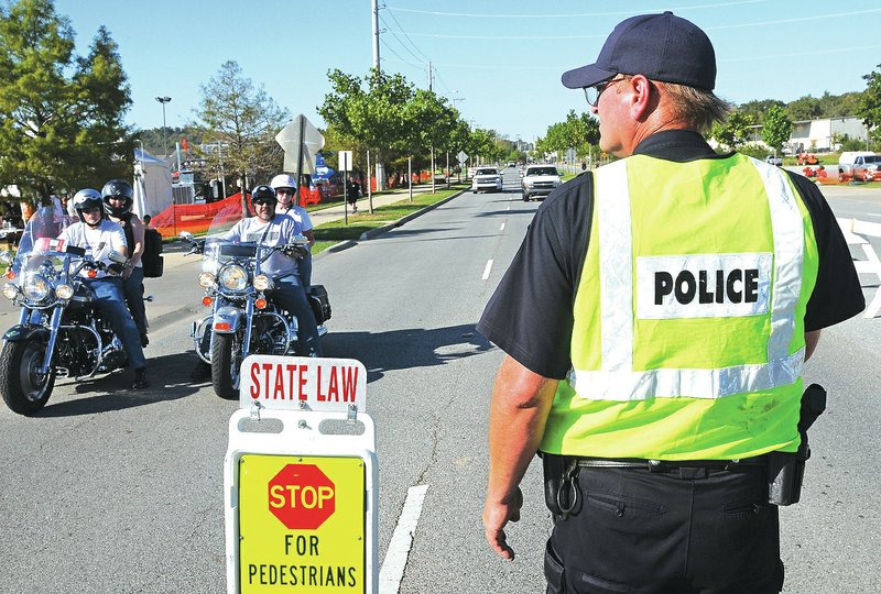 FILE PHOTO A Fayetteville policeman directs traffic near Baum Stadium during Bikes, Blues &amp; BBQ&#8217;s 2011 rally in Fayetteville.