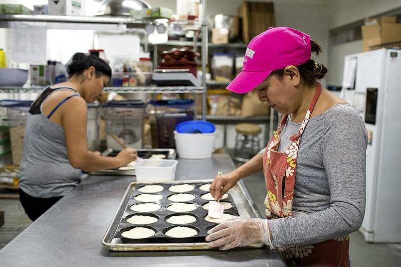 Employees at Free Bread, a manufacturer of gluten free breads, make hamburger buns in their kitchen at the Organic Food Incubator in Long Island City, in the Queens borough of New York, U.S., on Wednesday, July 16, 2014. The 20,000 square foot space offers commercial kitchens for small companies producing natural products. Photographer: Ron Antonelli/Bloomberg