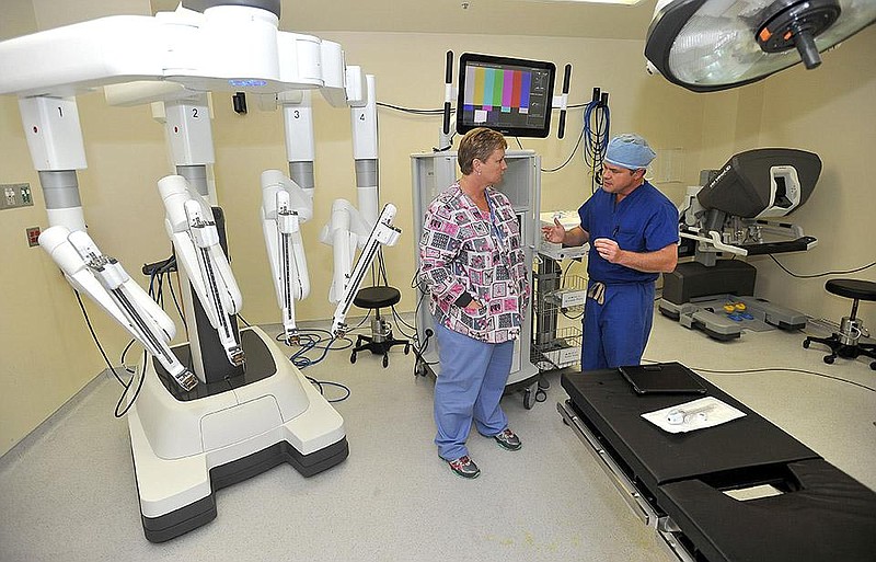 Jason Hurt, M.D., talks with robot operating room nurse and former patient Renee Gadberry, R.N., in front of the da Vinci Surgical System Wednesday Nov. 17, 2014 at Northwest Medical Center Springdale. (NWA Democrat-Gazette FILE PHOTO/Michael Woods)