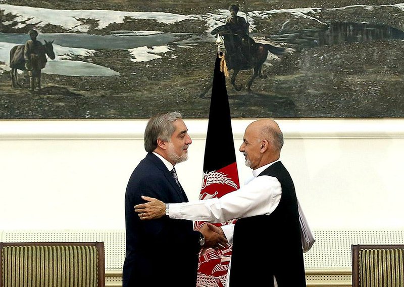 Afghanistan's presidential election candidates Abdullah Abdullah, left, and Ashraf Ghani Ahmadzai, right, shake hands after signing a power-sharing deal at the presidential palace in Kabul, Afghanistan, Sunday, Sept. 21, 2014. Afghanistan's two presidential candidates signed a power-sharing deal Sunday, capped with a hug and a handshake, three months after a disputed runoff that threatened to plunge the country into turmoil and complicate the withdrawal of U.S. and foreign troops. (AP Photo/Massoud Hossaini)