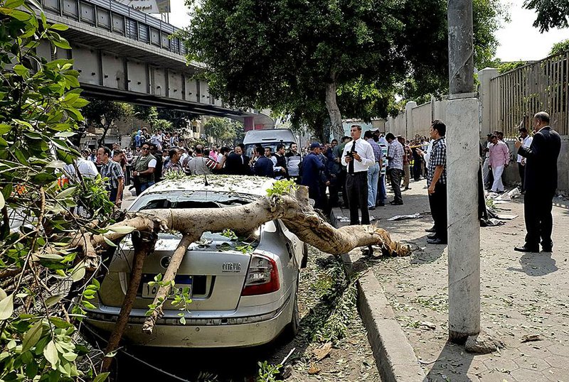 Egyptian security forces inspect the scene after a roadside bomb went off on a busy street in downtown near the foreign ministry, in Cairo, Egypt, Sunday, Sept. 21, 2014. Security officials said the Sunday explosion targeted a police checkpoint near the back gate of the ministry building. Several people were wounded, and senior policemen killed said the officials. (AP Photo/Aly Hazzaa, El Shorouk) EGYPT OUT