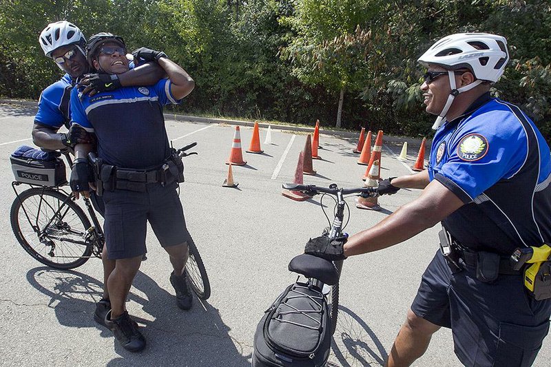 Arkansas Democrat-Gazette/BENJAMIN KRAIN --09/16/2014--
UALR police Lt. Johnny Smith, center, plays the role of a suspect while demonstrating ways of apprehending a suspect from bicycles during a training course for Little Rock police officers. UALR's Department of Public Safety has been utilizing bike patrols on their campus and were asked by the Little Rock Police Department to help prepare about 20 officers for their own bike patrol.
--WITH VIDEO---