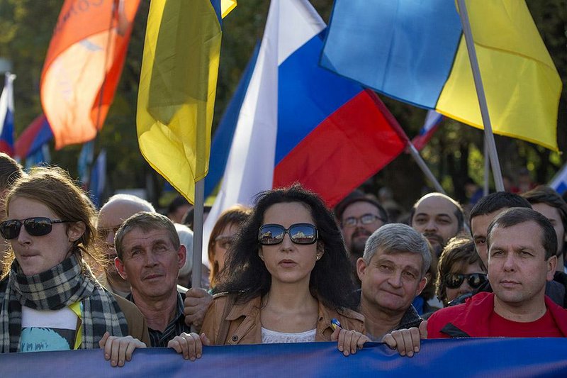 People take part in an anti-war rally in downtown Moscow, Russia, Sunday, Sept. 21, 2014.Thousands of people are marching through central Moscow to demonstrate against the fighting in Ukraine and Russia’s alleged complicity in the conflict.  (AP Photo/Pavel Golovkin)