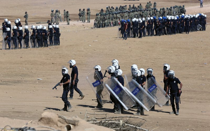 Riot police use teargas to disperse Kurdish demonstrators who were clashing with Turkish security forces as thousands of Syrian refugees continue to arrive at the border in Suruc, Turkey, on Monday, Sept. 22, 2014. Turkey opened its border Saturday to allow in up to 60,000 people who massed on the Turkey-Syria border, fleeing the Islamic militants’ advance on Kobani.
