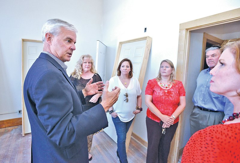  STAFF PHOTO BEN GOFF &#8226; @NWABen Goff U.S. Rep. Steve Womack, R-Ark., left, talks with a group from Main Street Rogers while touring the City Hall Lofts as part of a walking tour of new businesses in downtown Rogers on Monday. Other stops included Parkside Public, which hopes to open in November, and Brick Street Brews, which opened recently.