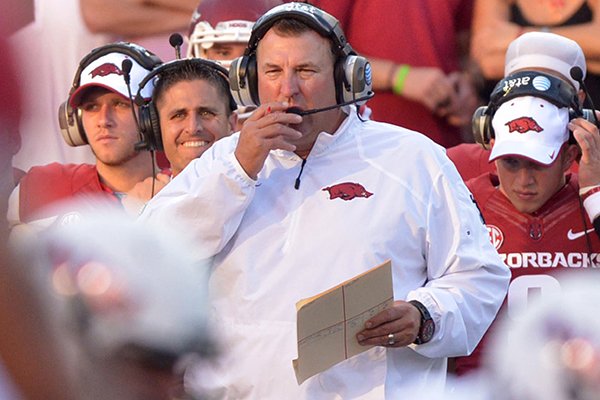 Arkansas coach Bret Bielema talks on his headset during the first quarter of the game against Northern Illinois at Reynolds Razorback Stadium in Fayetteville on Saturday, Sept. 20, 2014. 