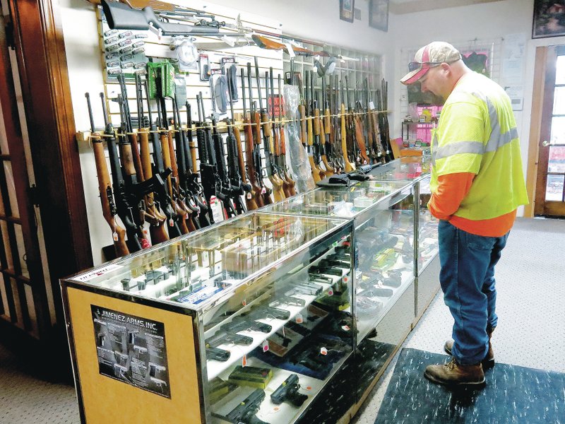 Photo by Susan Holland Scott Peters of Gentry was shopping recently at Cardinal Corner Pawn Shop in Gravette. He is seen here browsing among the excellent selection of firearms in stock at the shop. Cardinal Corner Pawn is a licensed federal firearms dealer and can accommodate customers who wish to purchase guns online and have them shipped to Gravette for pickup there.